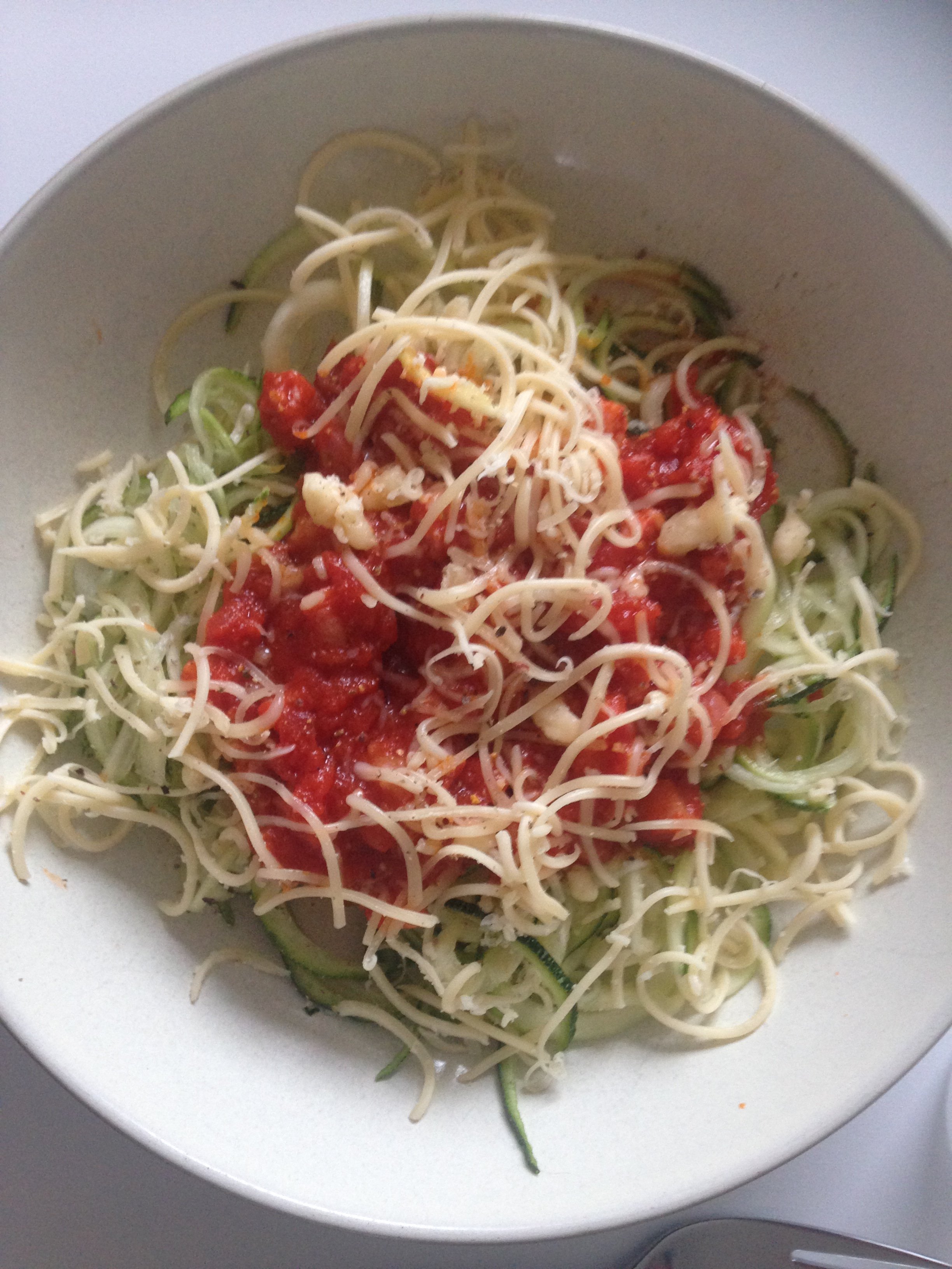 Keto courgette spaghetti met tomatensaus en geraspte kaas