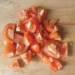 Houten snijplank met in stukken gesneden tomaat