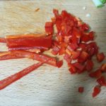 Houten snijplank met in stukjes gesneden chili peper