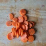 Snijplank met in dunne plakjes gesneden winterwortel.