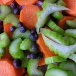 Kom met fijngesneden groente en jeneverbessen voor de marinade